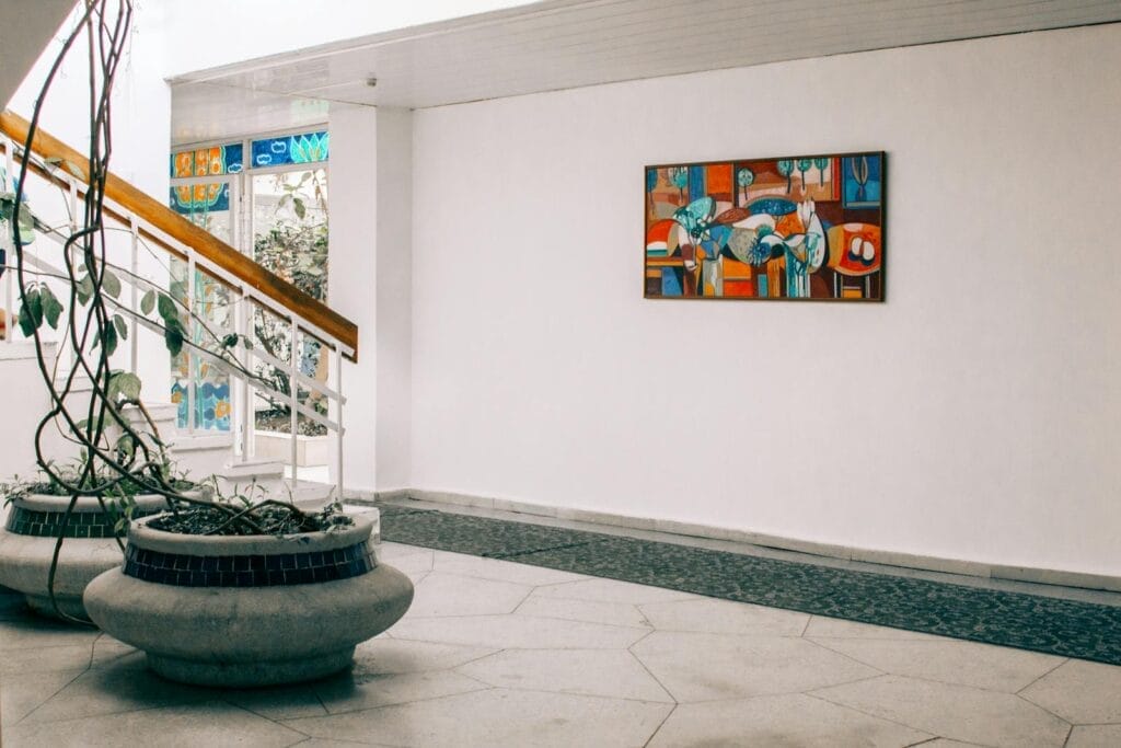 Sleek hall with modern art and planters, showcasing contemporary interior design.
